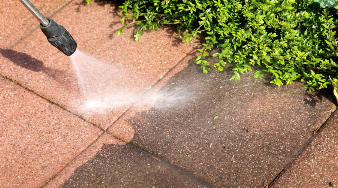 A man cleaning outdoor by pressure washing technique